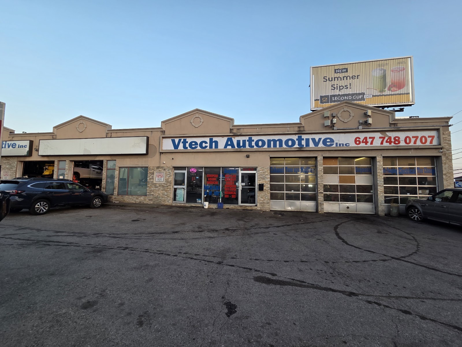 Vtech Automotive storefront on Lawrence Ave W, three roll-up bay doors and signage