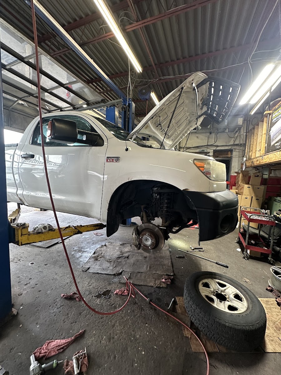 Toyota Tundra on a two-post lift with the front wheel removed for brake service
